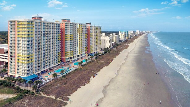 Un hôtel situé en bord de mer, doté de plusieurs étages, d’une piscine et d’un accès direct à la plage.