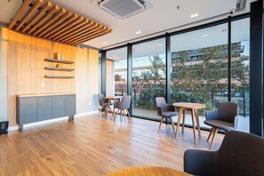 Een modern interieur met een houten plafond, inbouwkasten en een stadsgezicht door grote ramen.