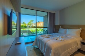 A hotel room with a large window, a bed, a TV, and a small table. - Beach Class Summer by Carpediem (Ipojuca)