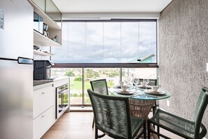 Une cuisine moderne avec un coin repas, de grandes fenêtres et une vue sur la ville.