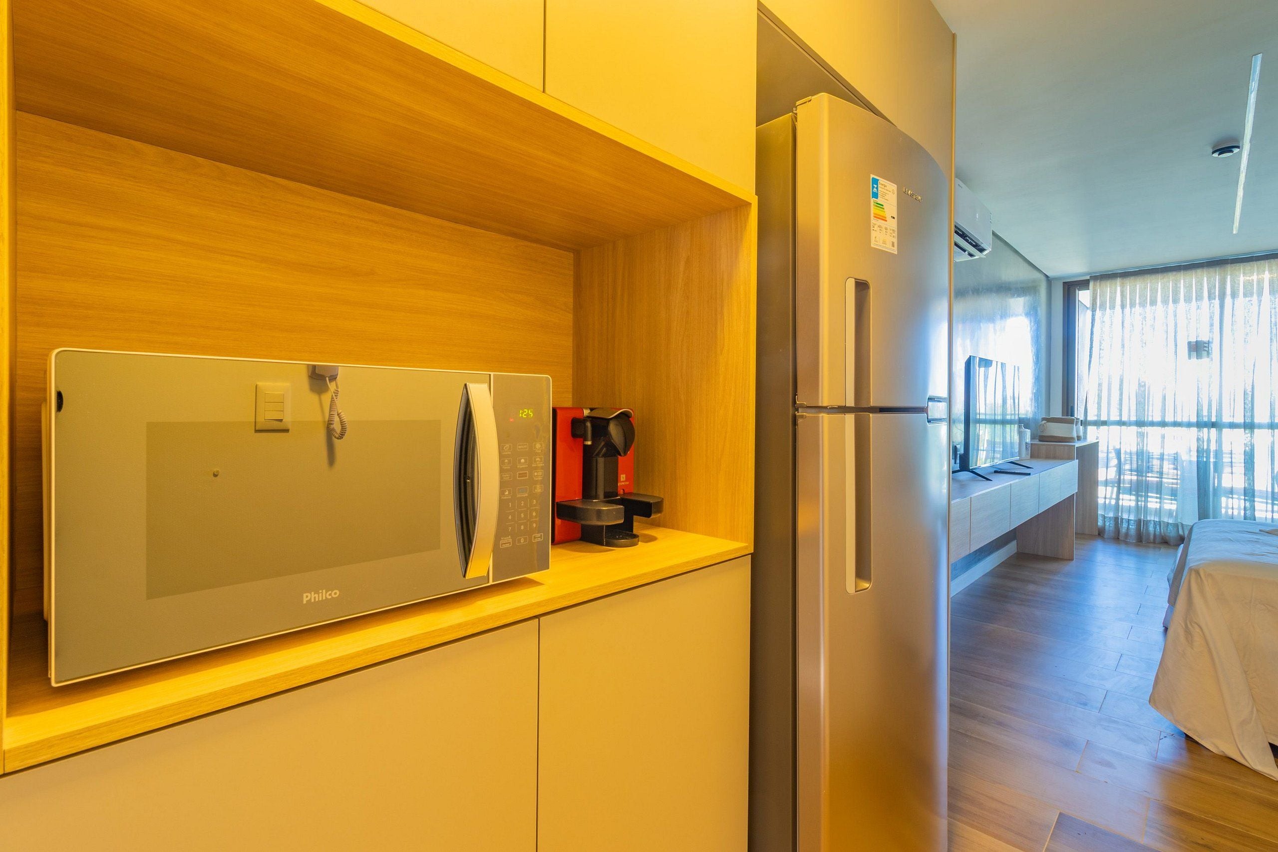 Uma cozinha moderna equipada com micro-ondas, geladeira e máquina de café.