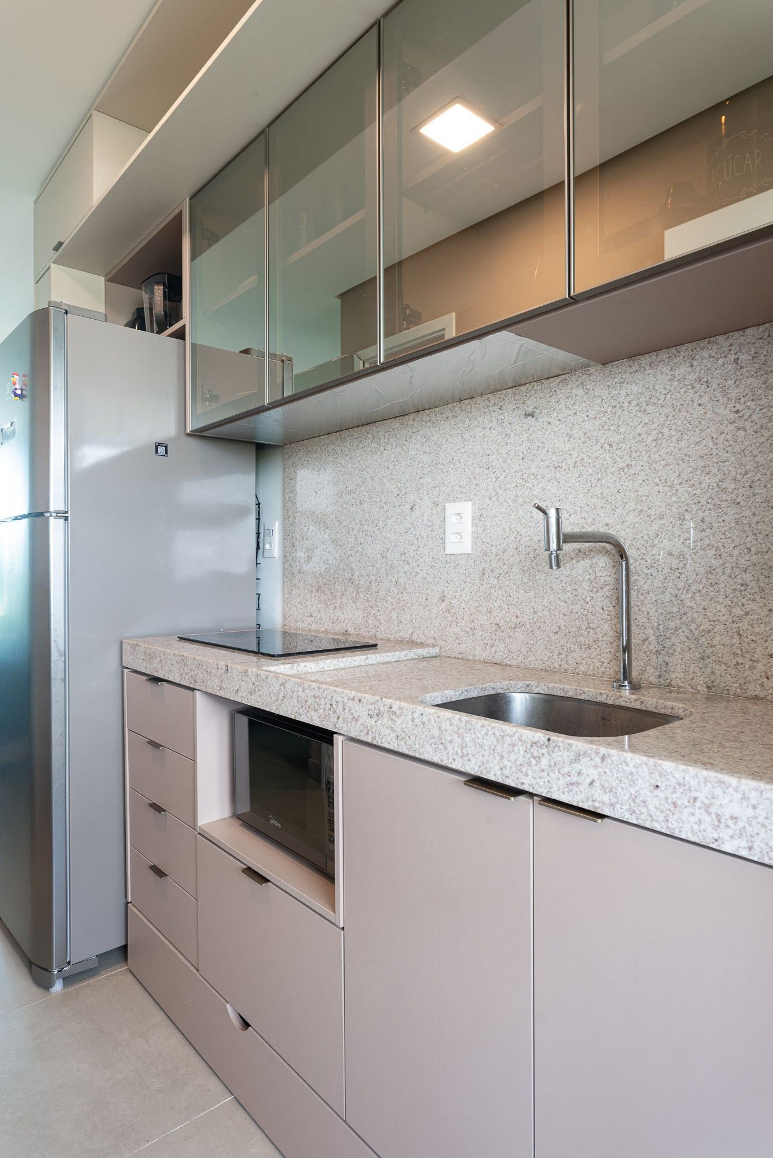 Una cocina moderna con refrigerador de acero inoxidable, encimera de granito y lavavajillas integrado.