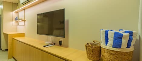 A reception desk with a flat-screen TV, a woven basket, and a striped towel.