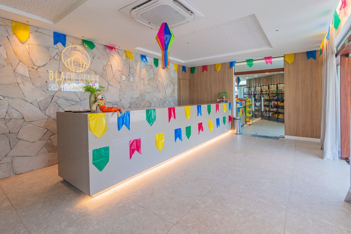 A reception area with a stone wall, a neon sign, a counter, and colorful flags.