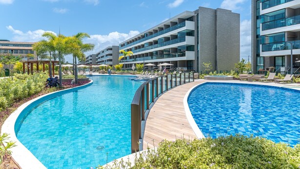 A modern hotel with a large swimming pool, multiple balconies, and a well-maintained garden area. - Beach Class Summer by Carpediem (Ipojuca)