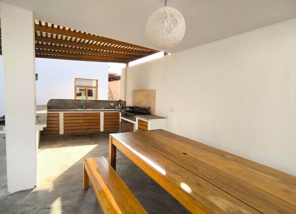 Une cuisine moderne avec des meubles en bois, une cuisinière encastrée et un luminaire suspendu.