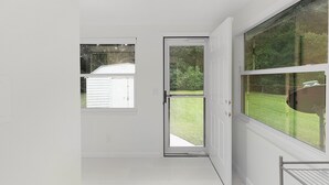 A room with a white door, a window, and a view of a grassy yard. - Family-Friendly  sleeps 7-Home Close to Fun (Belleview)