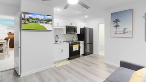 A modern kitchen with white cabinets, a black refrigerator, and a ceiling fan. - Family-Friendly  sleeps 7-Home Close to Fun (Belleview)