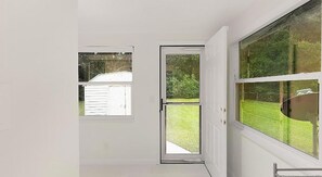 Una habitación con un amplio ventanal corredero que da a un patio trasero.