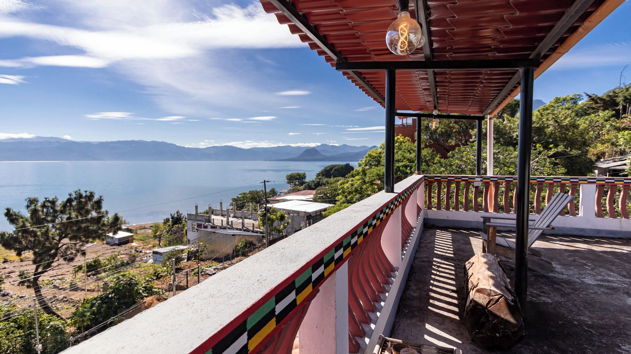 Un balcón con vistas al agua y a las montañas.