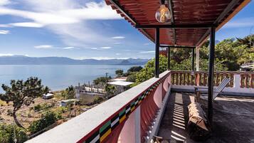 Un balcón con vistas al agua y a las montañas.