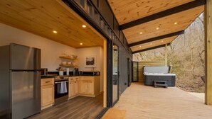A modern kitchen with wooden cabinets, a stainless steel refrigerator, and a microwave. - Shipping Container at Double Nickel Farm (Hurricane)
