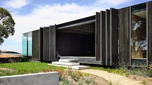 A modern building with a large glass facade, a flat roof, and a minimalist design.
