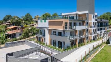 A multi-story building with balconies, a rooftop terrace, and a landscaped area.