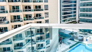 A modern hotel with multiple balconies, a rooftop pool, and a glass atrium. - Stayshort - Peaceful Studio in Production City That Sleeps 3 (Dubai)