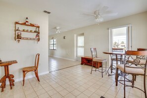 A spacious living room with a dining area, a ceiling fan, and a large window. - Waterfront Gulf Access Beach House w Lainai (Port Charlotte)