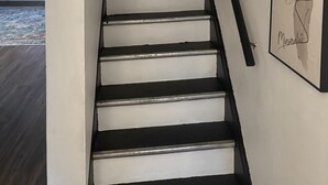A staircase with a handrail, leading to a landing with a door.