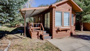 A small log cabin with a covered porch and a staircase leading to the entrance. - #244 Tiger Run (Breckenridge)