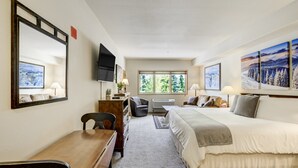 A hotel room with a bed, desk, chair, TV, and large windows. - #5072 Keystone (Keystone)