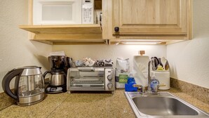 A kitchen with a microwave, toaster, kettle, coffee maker, and a sink. - #5072 Keystone (Keystone)