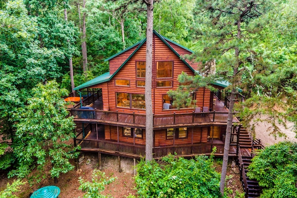 Multi-level log cabin with green roof, wraparound decks