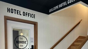 Ein Hotelbüro mit einem Schild, auf dem “HOTEL OFFICE” und “WILKOMMEN HOTELGÄSTE” steht.