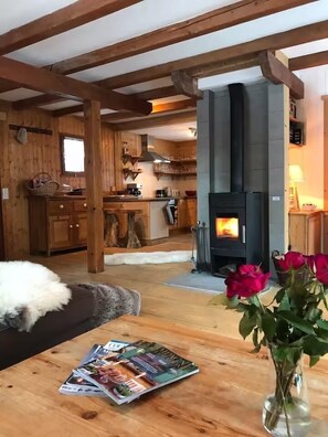 Ein gemütliches Holzinterieur mit Kamin, Essbereich und Küche.