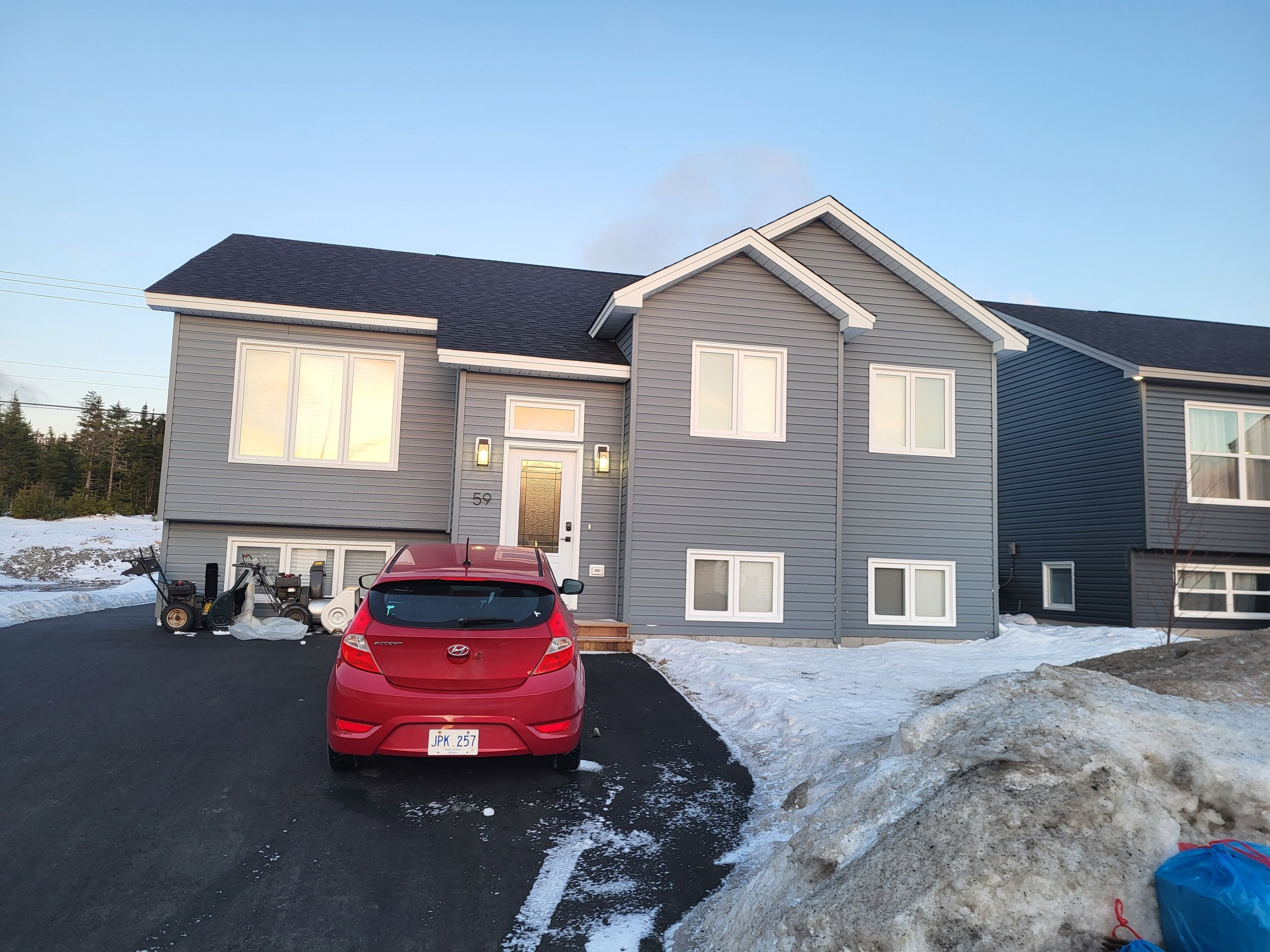 A two-story residential building with a grey exterior and white trim.