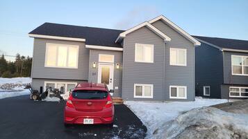 A two-story residential building with a grey exterior and white trim.