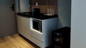 A modern kitchen with a built-in oven, a microwave, and a coffee machine. - W Tambaú (João Pessoa)