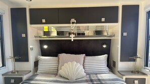 Ein modernes Schlafzimmer mit einem Bett, Nachttischen und einem Einbauschrank über dem Bett.
