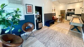 Un salon moderne avec une cheminée, un coin repas et une cuisine.