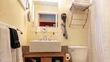 A bathroom with a sink, toilet, and shower.