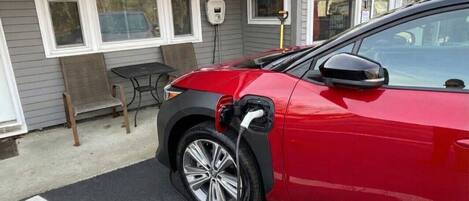 A red car parked at an electric charging station.