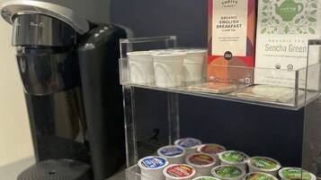 A coffee machine, a display of tea boxes, and a shelf with tea containers.