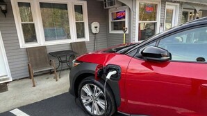 Ein rotes Auto an einer Ladestation für Elektroautos.
