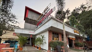 A hotel with a signboard in multiple languages, a paved entrance, and potted plants around the building. - Hotel Anuha (Mira Bhayandar)