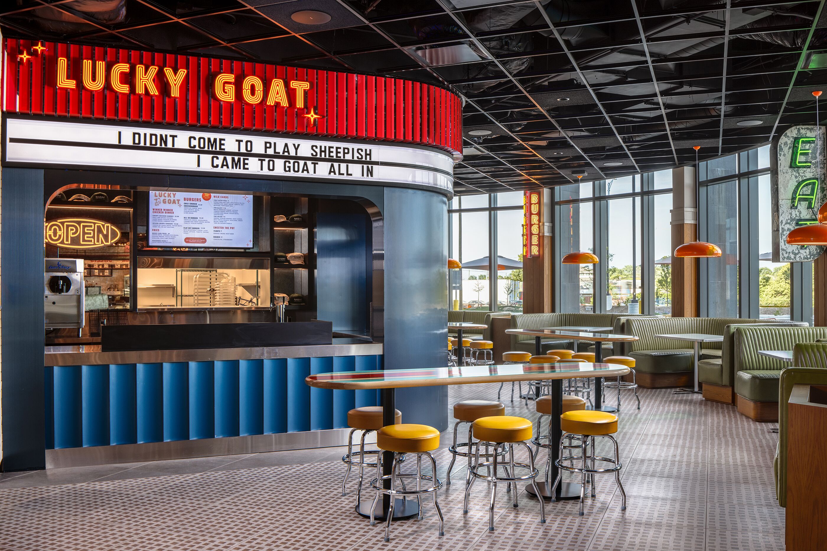 A restaurant interior with a counter, menu, and seating area.