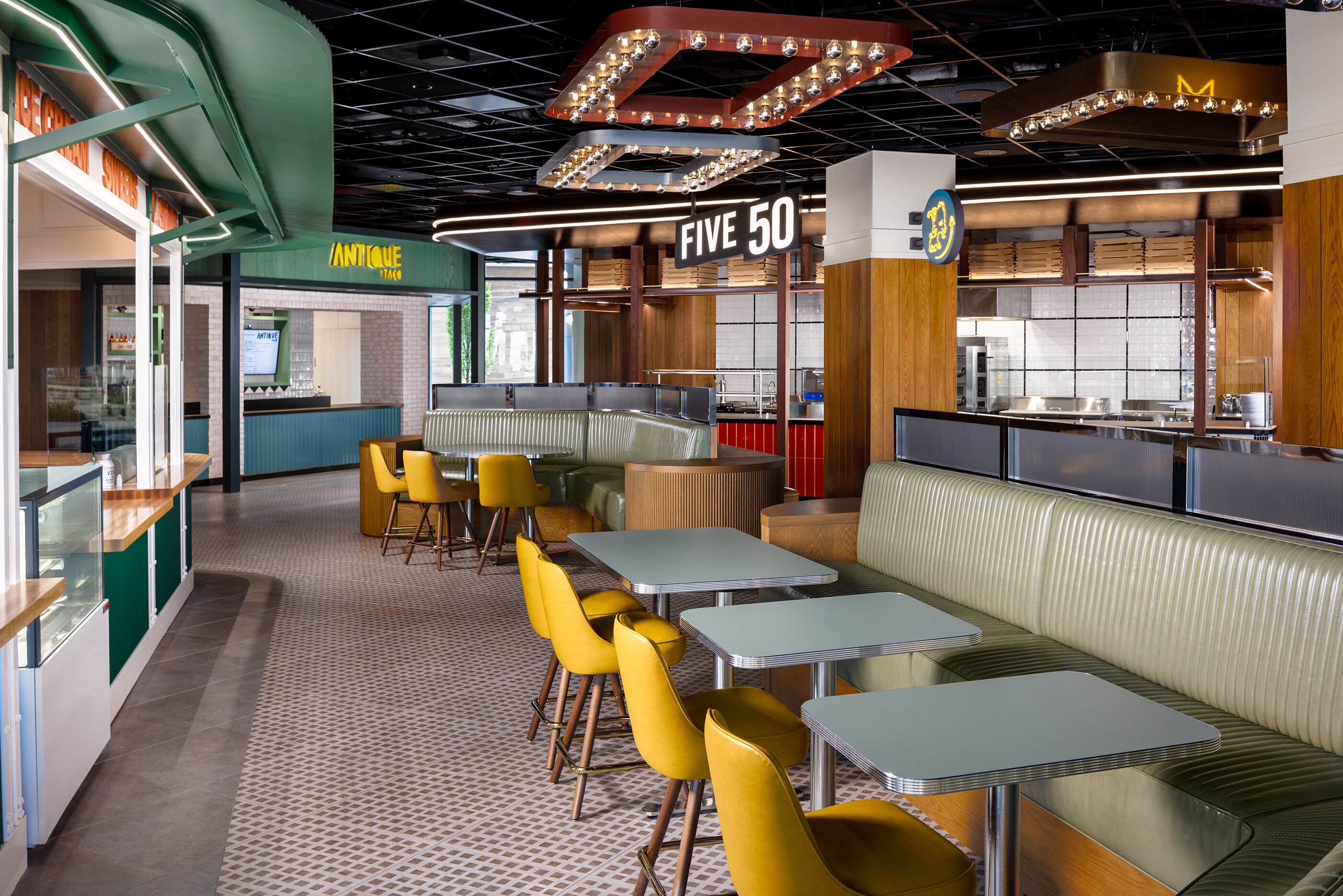 Un interior de restaurante moderno con cabinas, mesas y una zona de barra.