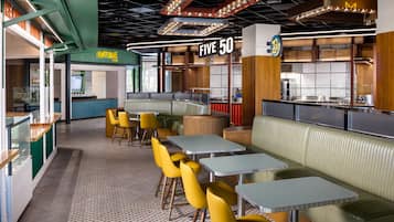 Un interior de restaurante moderno con cabinas, mesas y una zona de barra.