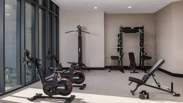 A gym with exercise equipment including a treadmill, stationary bike, and weightlifting station.