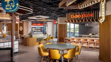 A modern restaurant interior with a sushi bar, seating areas, and a pizza counter.