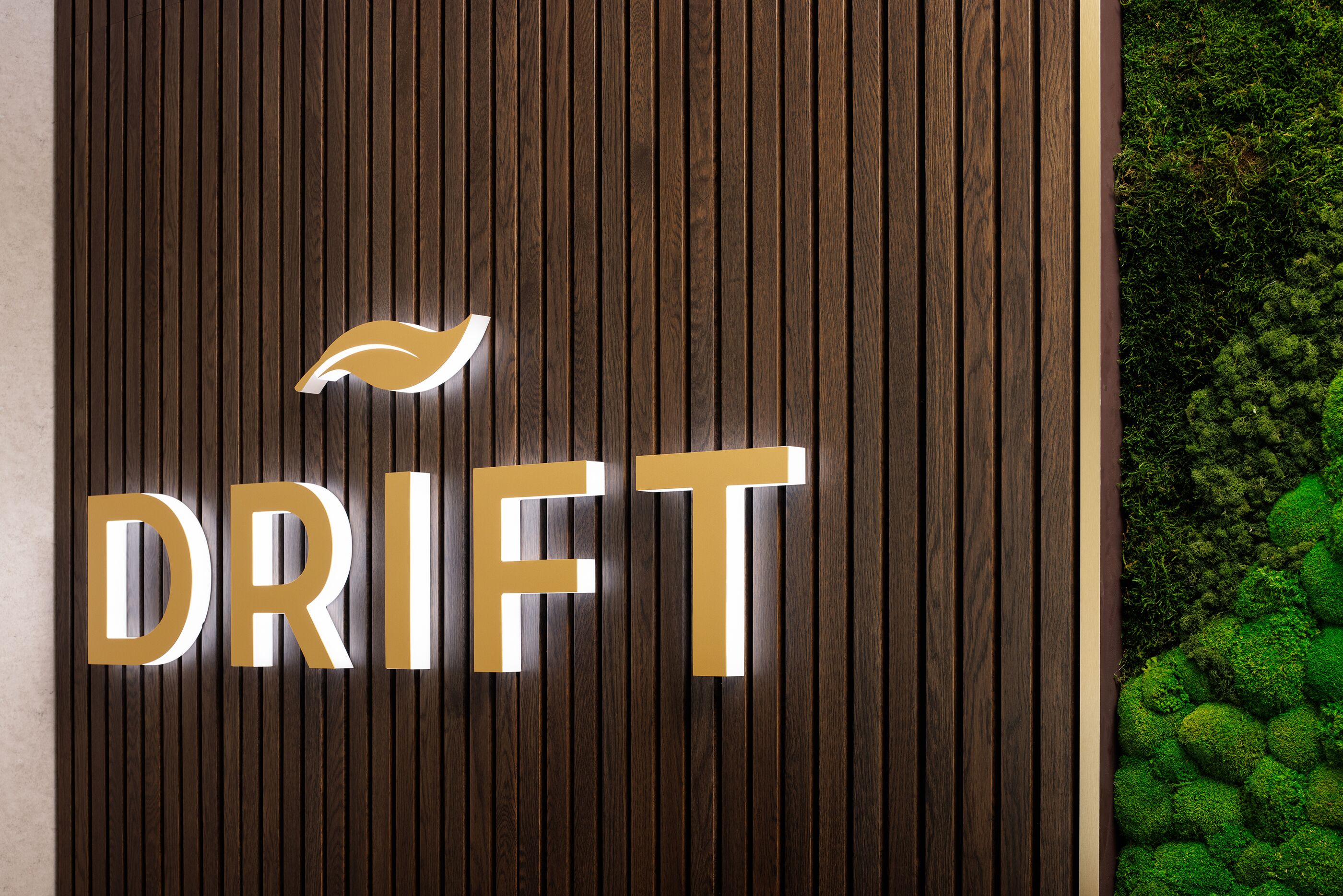 A wooden wall with the word 'DRIFT' in large, gold letters and a stylized bird logo.