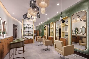 A modern salon interior with multiple seating areas, mirrors, and shelves with hair products.