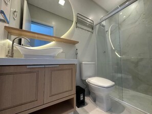 A modern bathroom with a glass shower enclosure, a white sink, and a toilet. - Mirante do Oceano guesthouse, 70 meters from the beach, with a heated pool. (Bombinhas)