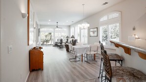 A spacious dining area with a high ceiling, large windows, and a view of the outdoors. - Desert Escape in Indian Palms | Golf Cart Included | Near Coachella & Tennis Gardens #051797 (Indio)