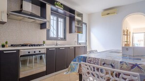 Eine moderne Küche mit Einbauherd, Backofen und einem Essbereich mit Tisch.