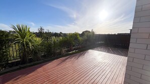 A wooden deck with a view of a garden and a clear sky. - Riverview Sunset Getaway - 4 bedroom 2.5 bathroom and stunning view (Hamilton)