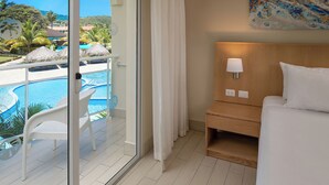 Quarto de hotel com porta de vidro para área da piscina, cama com cabeceira de madeira e um quadro na parede.