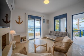 Ein modernes Wohnzimmer mit einer Couch, Sesseln, einem Tisch und einem Kamin.